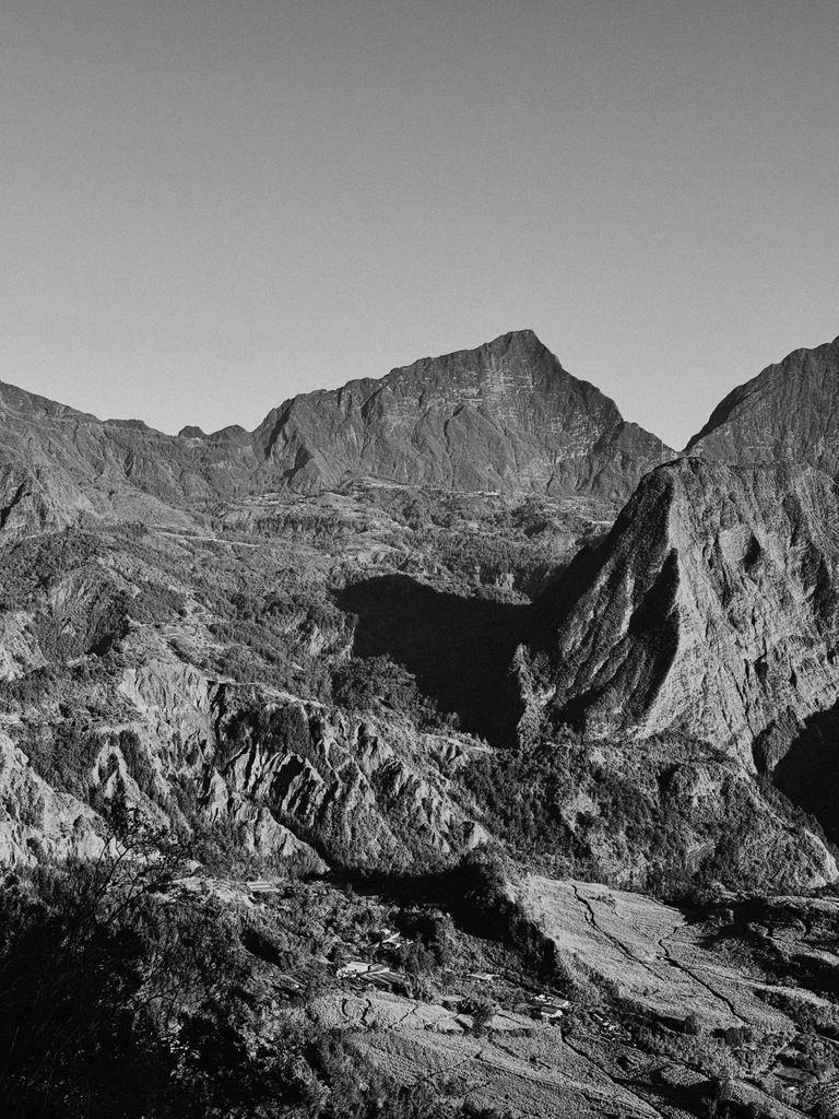 Majestic mountain scene in Réunion captured in black and white, highlighting rugged peaks and textures.